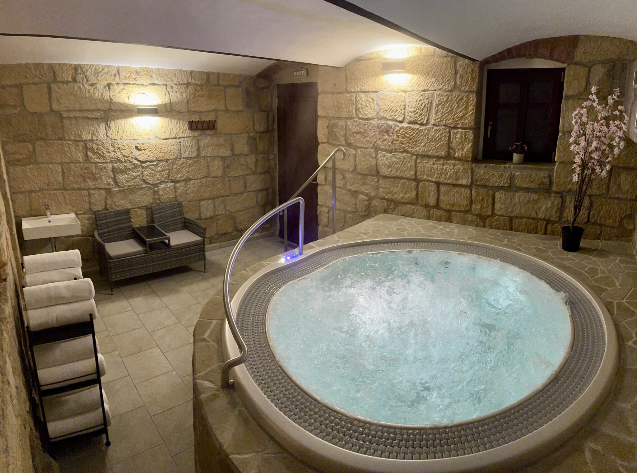 Privátní vířivka s masážními tryskami v přírodním pískovcovém interiéru wellness v Resortu Mezná, ideální pro relaxaci a regeneraci po aktivním dni v Českém Švýcarsku.